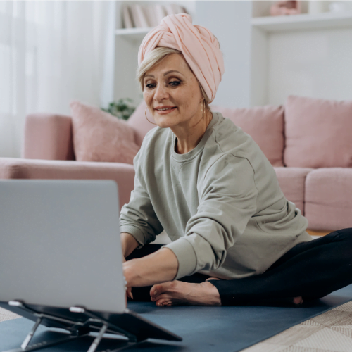 older woman on laptop doing yoga